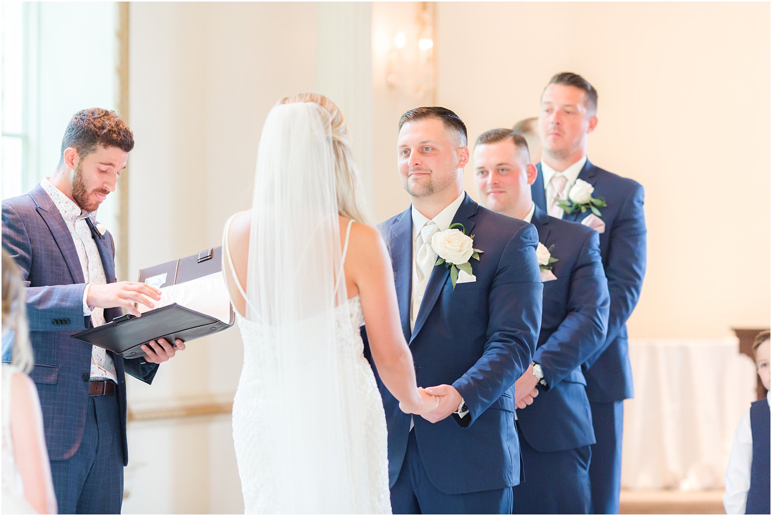 groom hold bride's hands smiling during wedding ceremony in chapel at Brigalia's