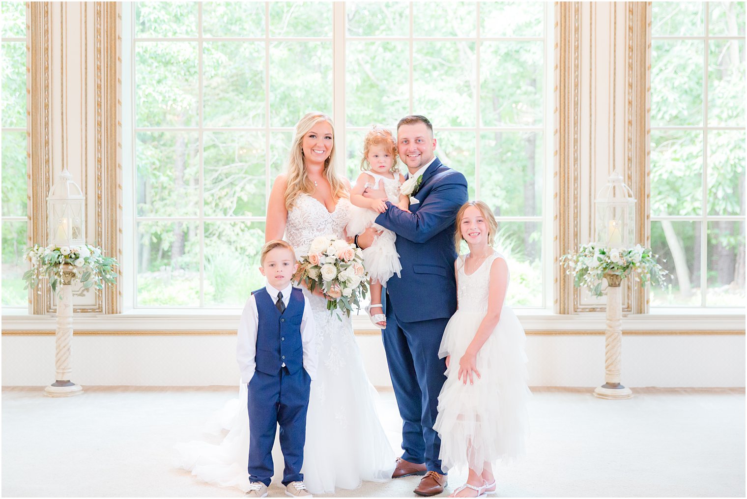 bride and groom pose with flower girls and ring bearer 