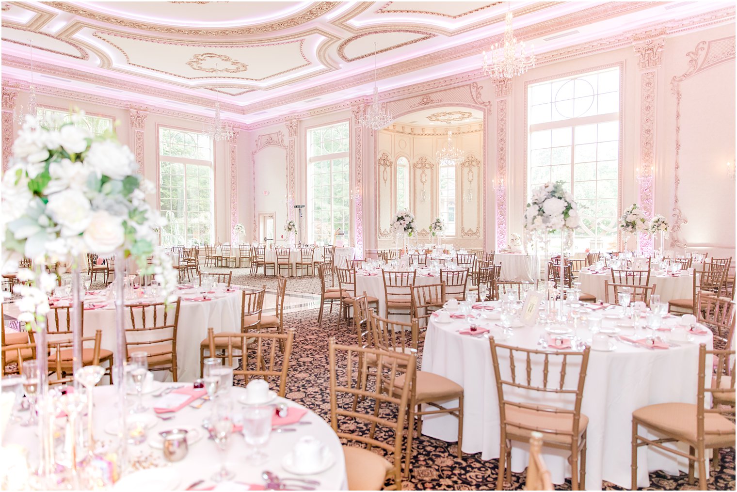 wedding reception with gold chivari chairs and pink uplighting at Brigalia's