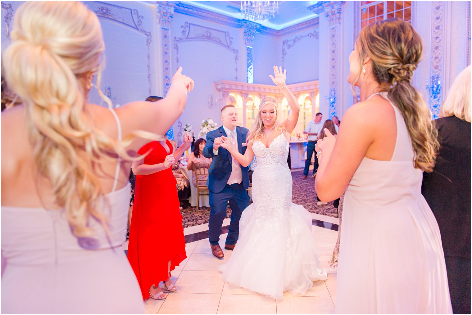 bride waves and dances with bridesmaids during reception