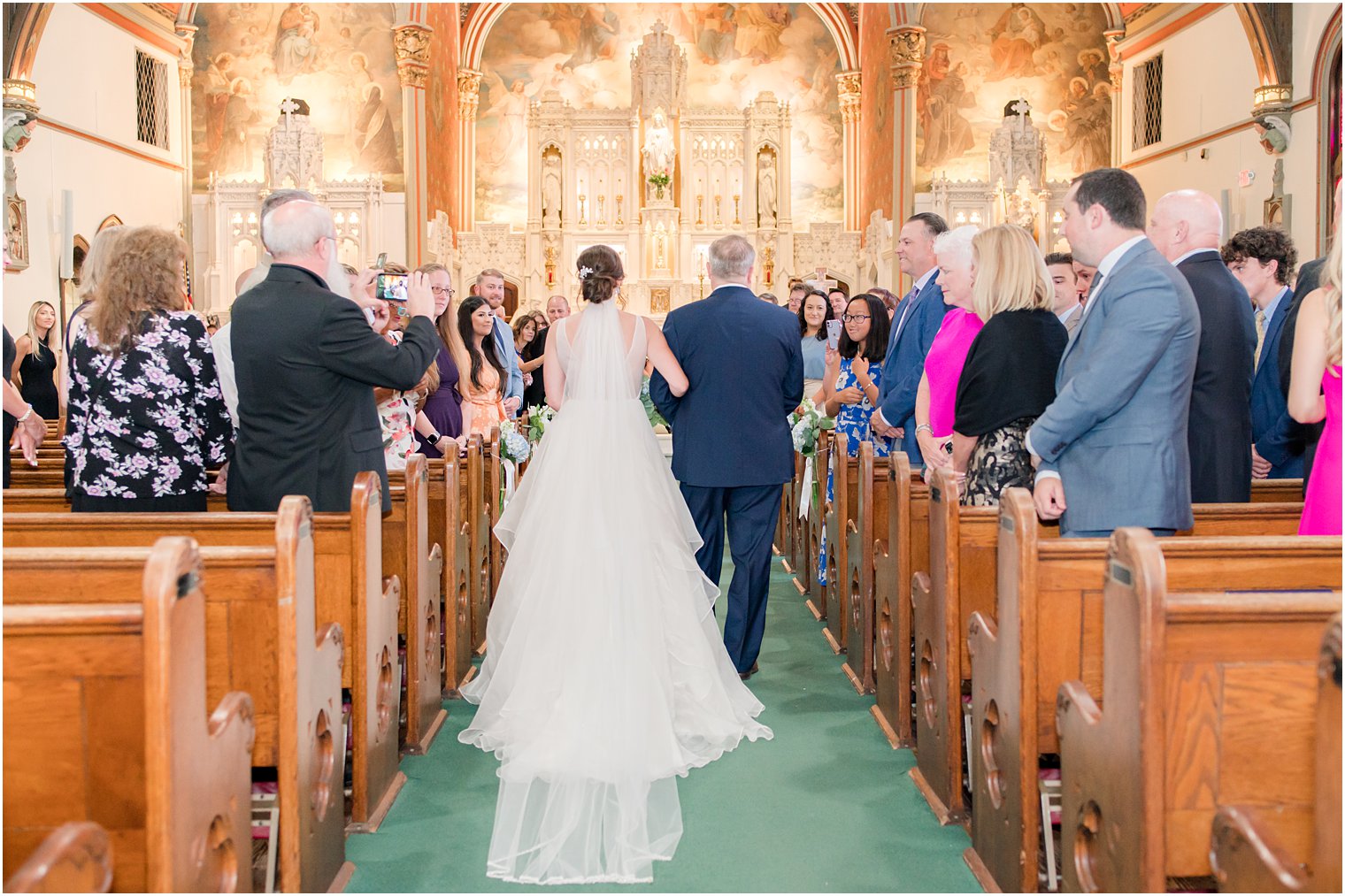 bride walks down aisle with father during traditional church wedding ceremony at St. Peter's Church