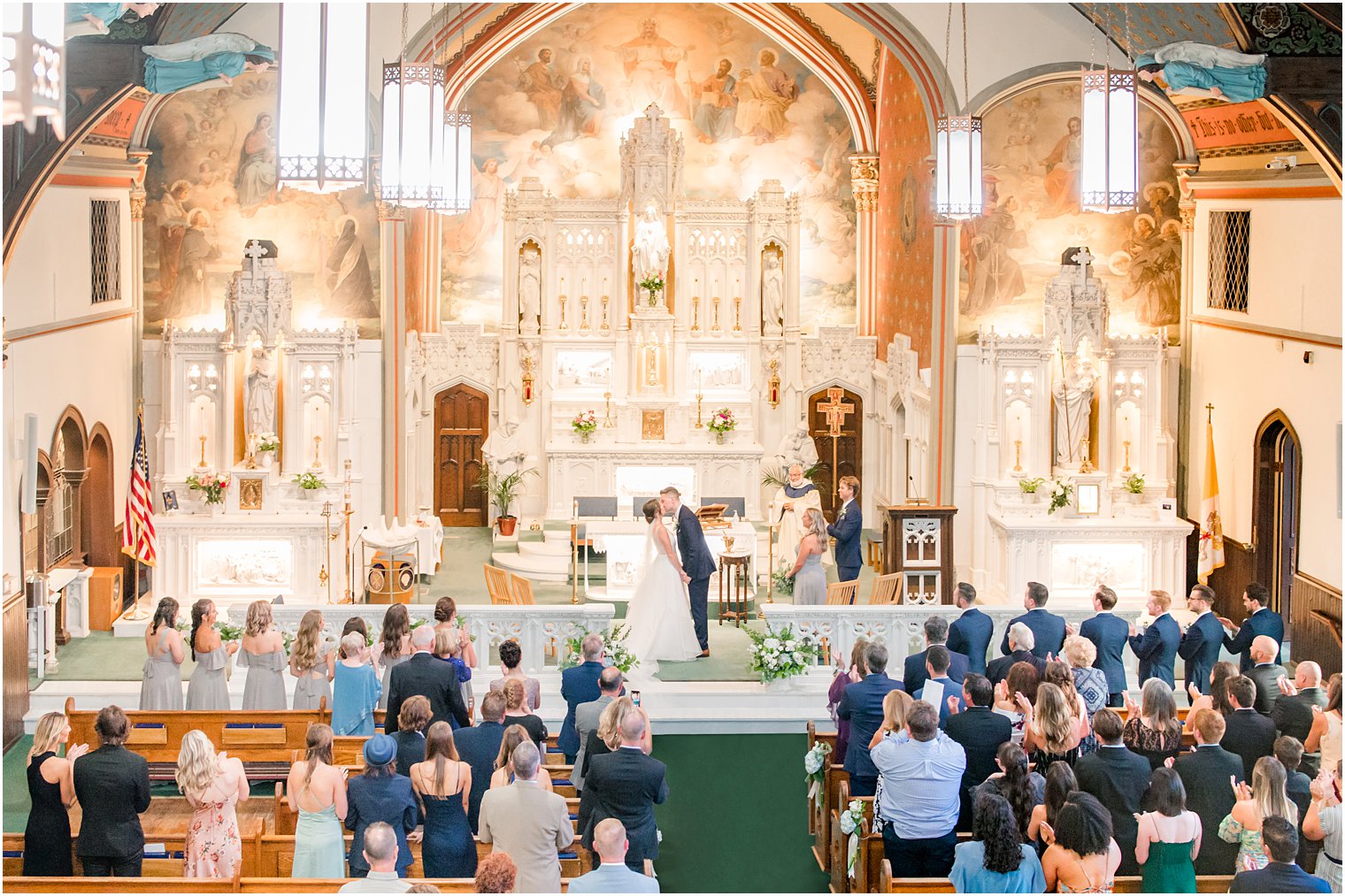 newlyweds kiss at alter during traditional church wedding ceremony at St. Peter's Church