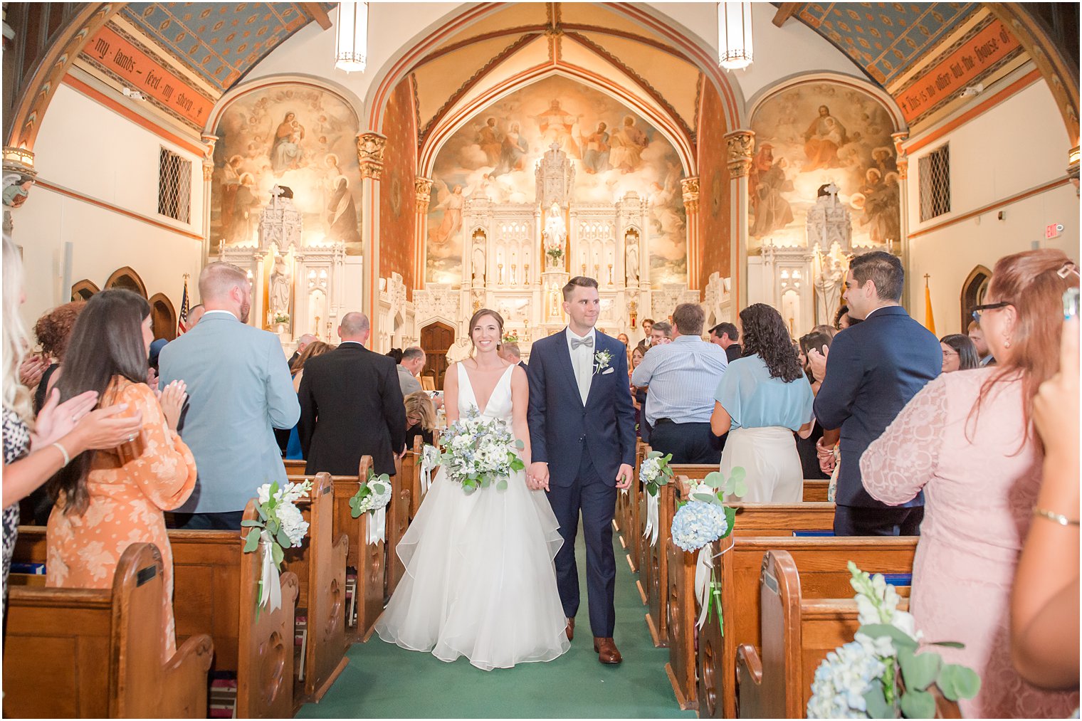 newlyweds walk up aisle after traditional church wedding ceremony at St. Peter's Church