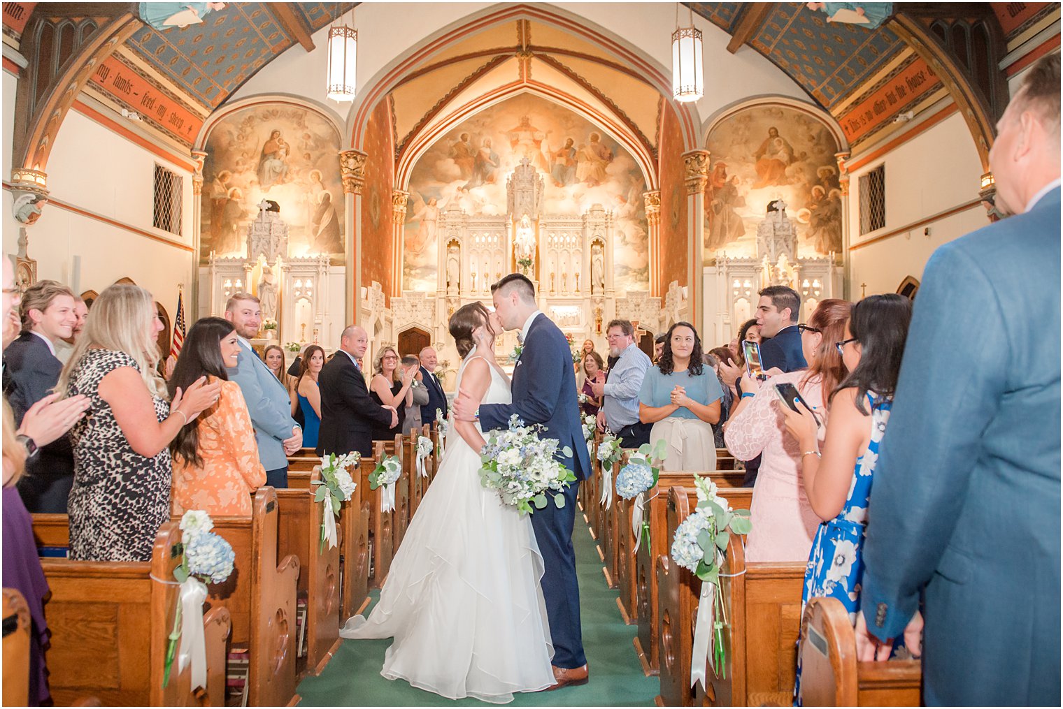 bride and groom kiss in aisle after traditional church wedding ceremony at St. Peter's Church