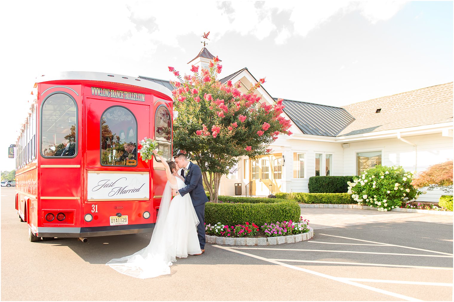 bride and groom kiss by red trolley in New Jersey 