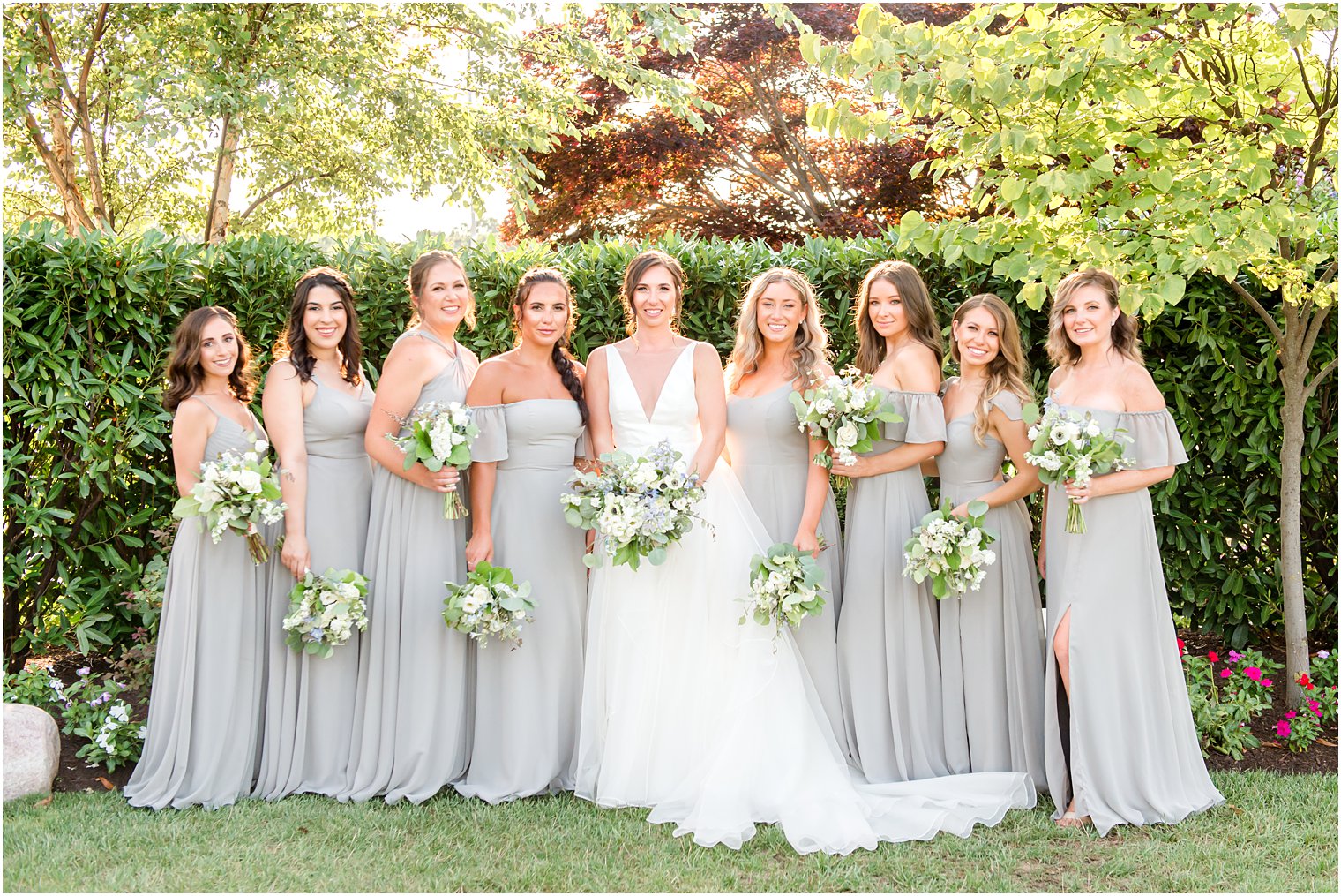 bride poses with bridesmaids in grey gowns