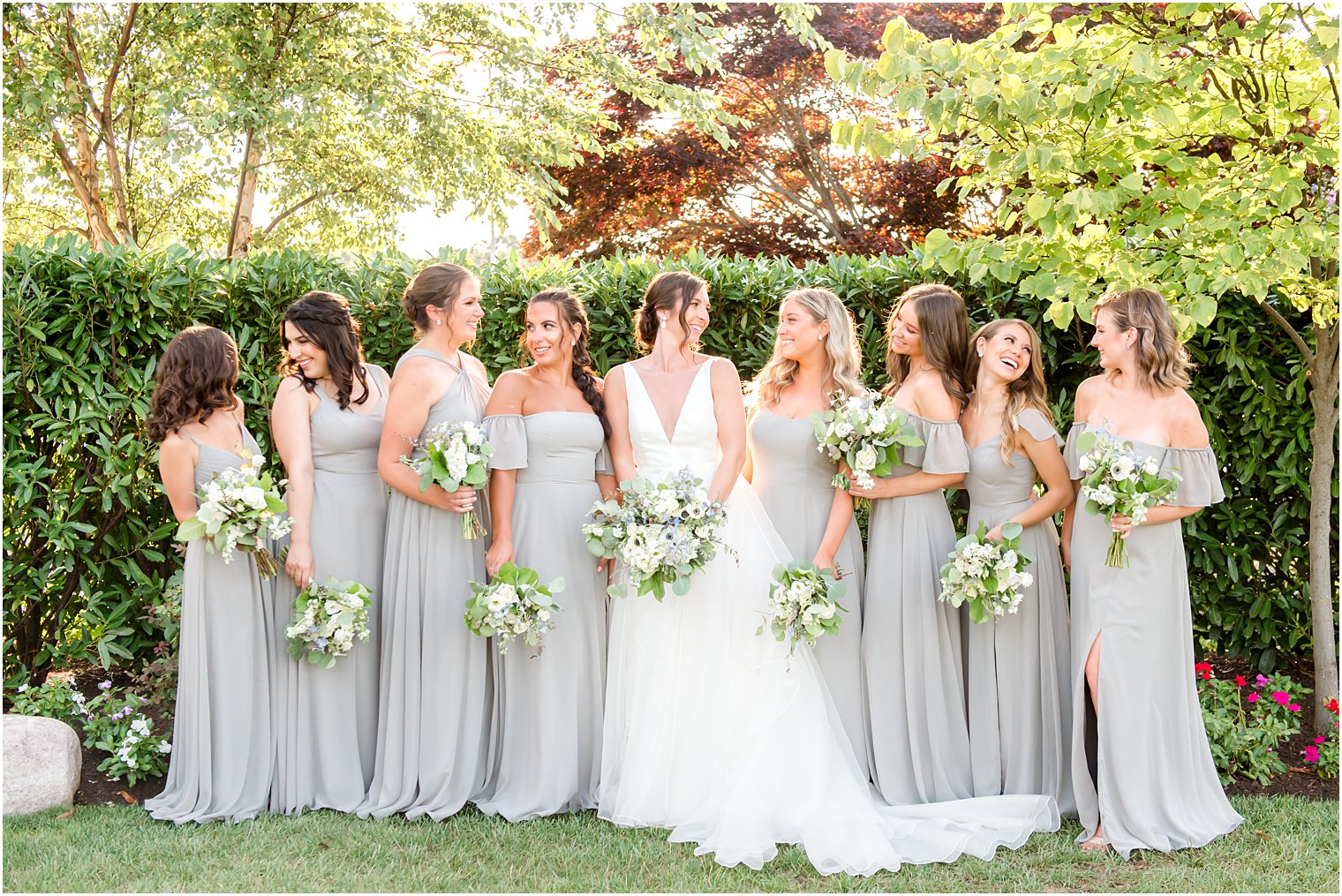 bride laughs with bridesmaids in grey gowns 