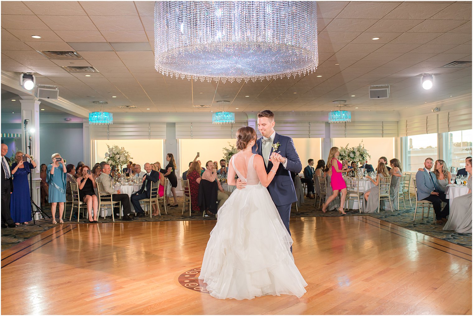 bride and groom dance under chandelier at Crystal Point Yacht Club