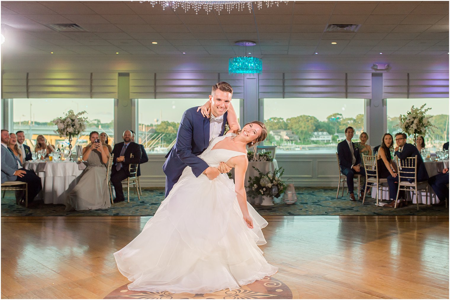 groom dips bride during first dance at Crystal Point Yacht Club