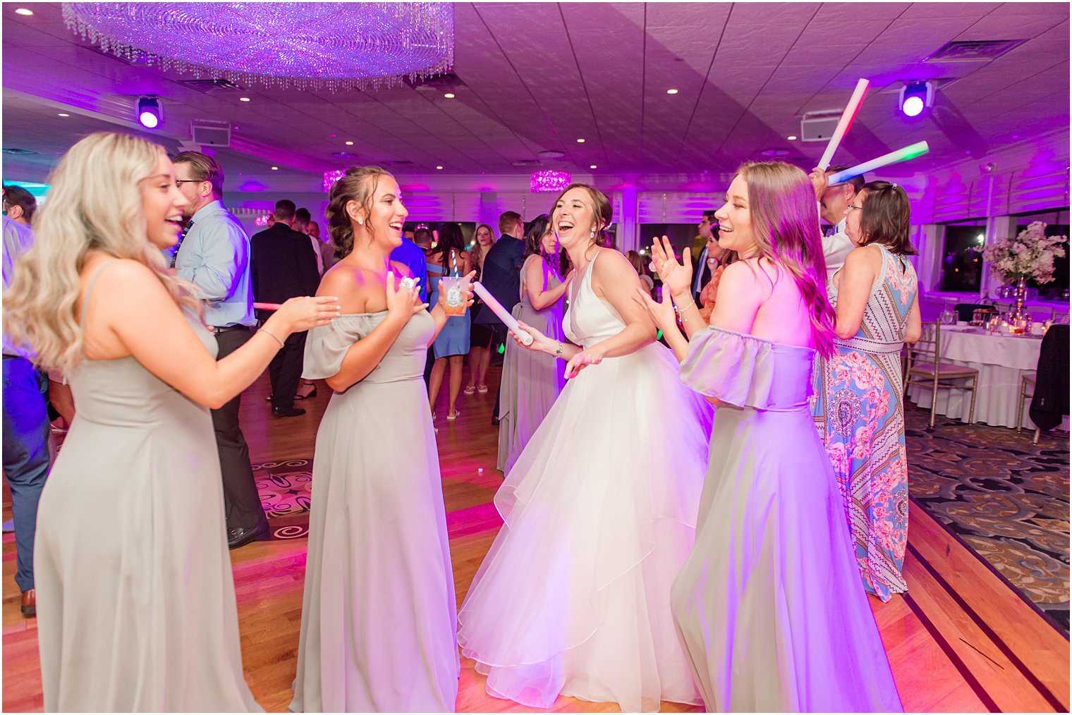 bride laughs during wedding reception at Crystal Point Yacht Club with bridesmaids 
