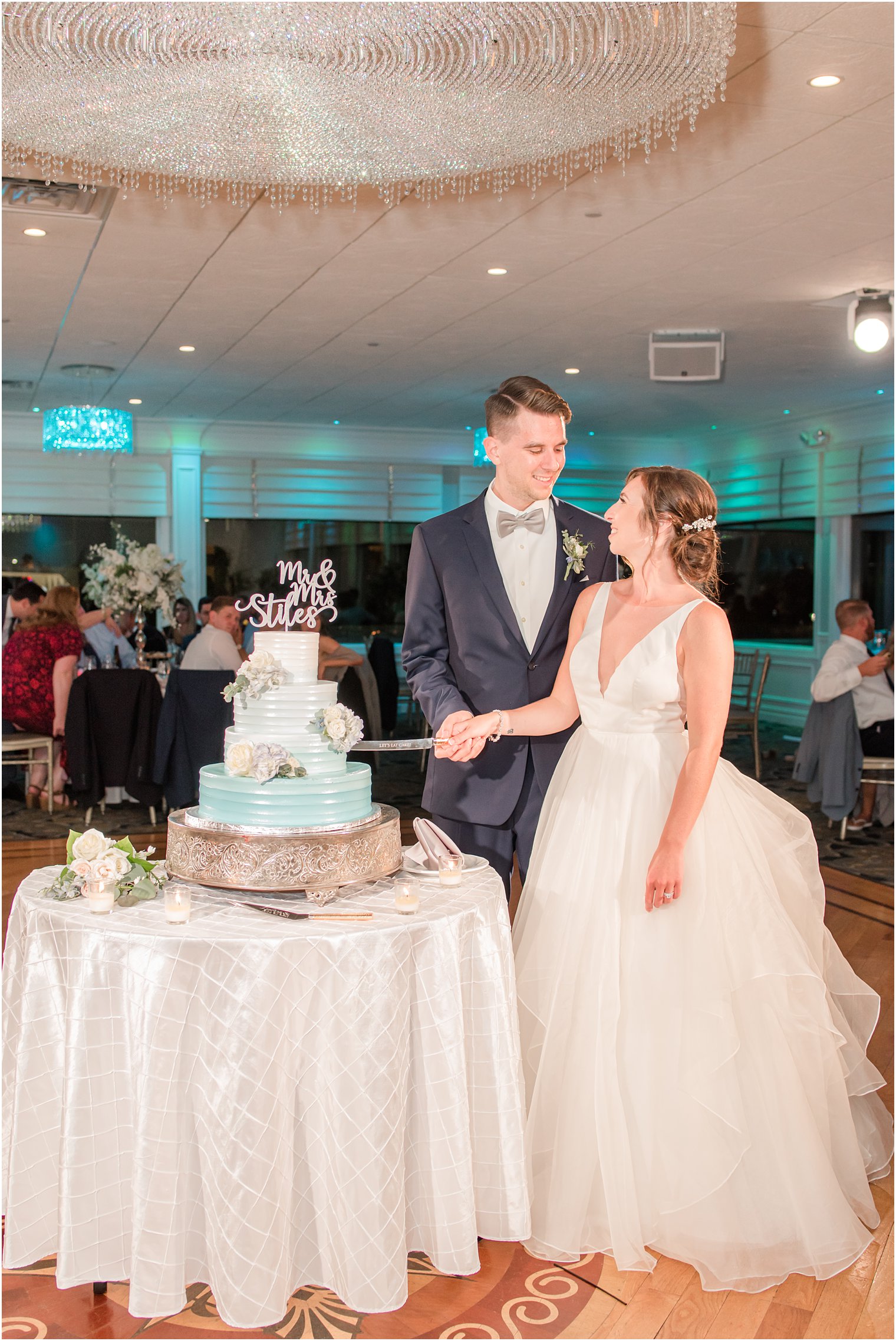 newlyweds cut wedding cake with blue icing