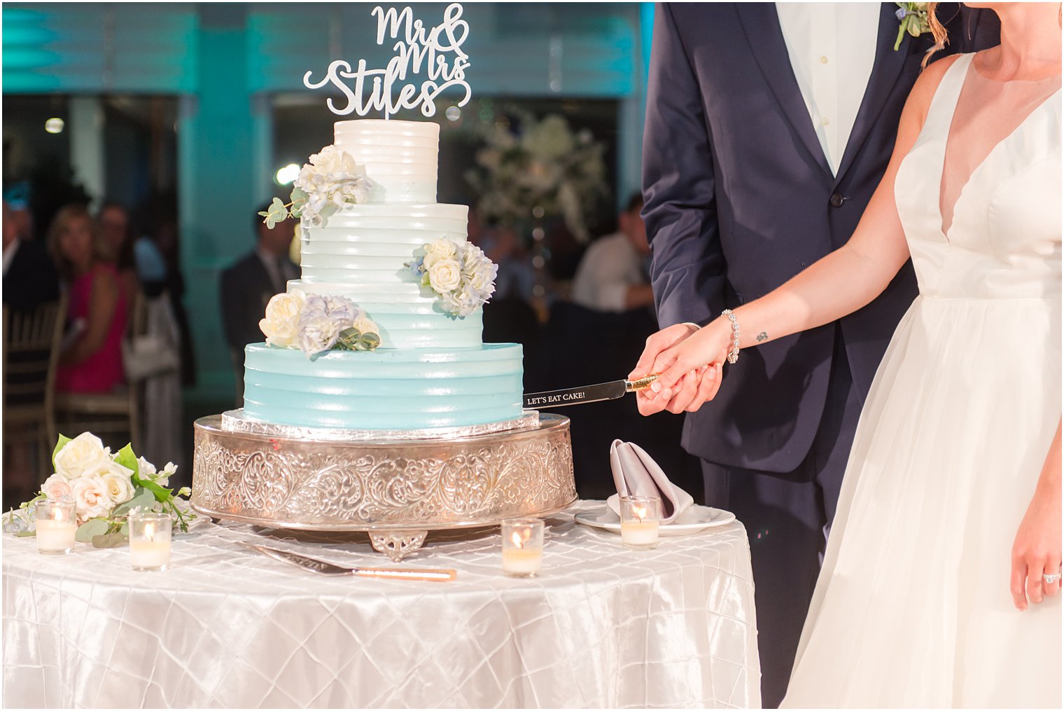 bride and groom hold cake knife together cutting cake