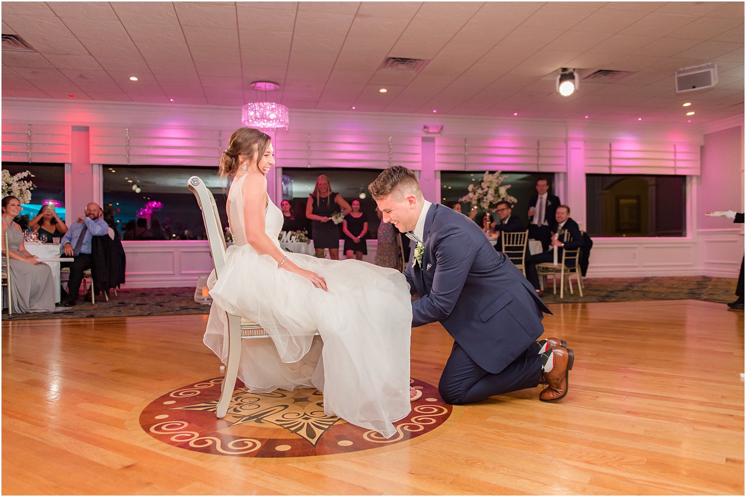 groom reaches for garter under bride's skirt at Crystal Point Yacht Club