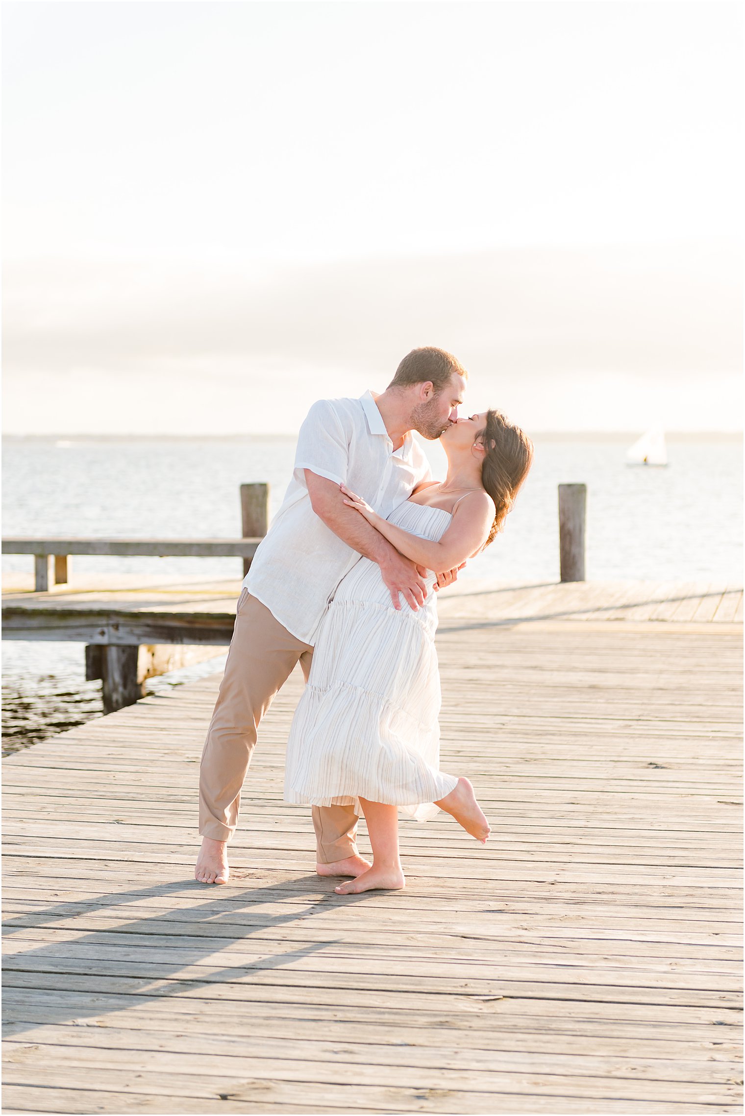 groom dips bride on wooden dock at Lavallette Beach