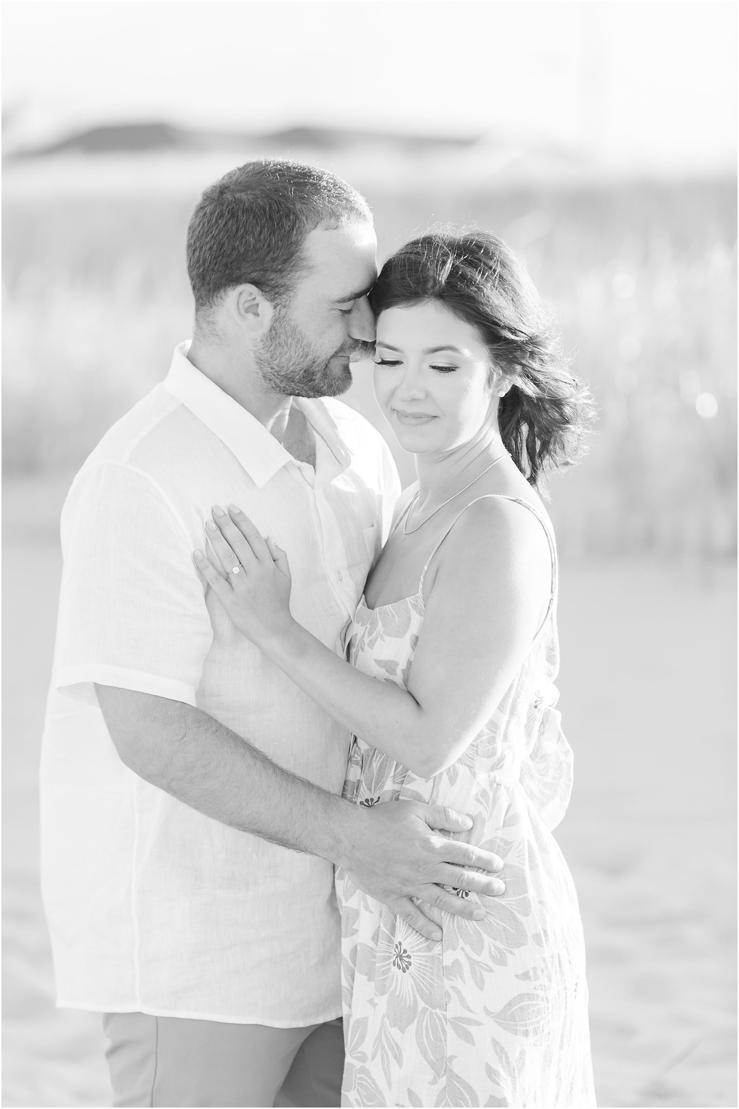 black and white photo of man hugging fiancee at Lavallette Beach