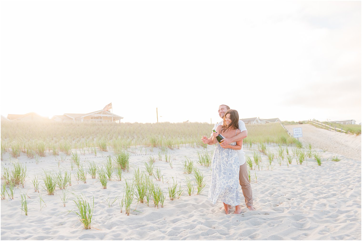 engaged couple hugs among sea grass and dunes during Lavallette Beach engagement session