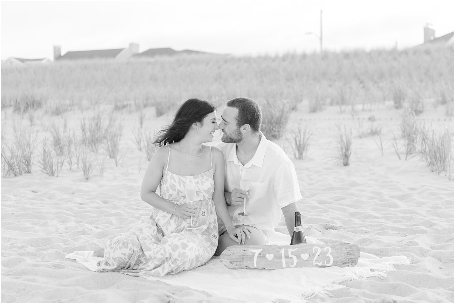 bride and groom sit on blanket on sand dunes at Lavallette Beach