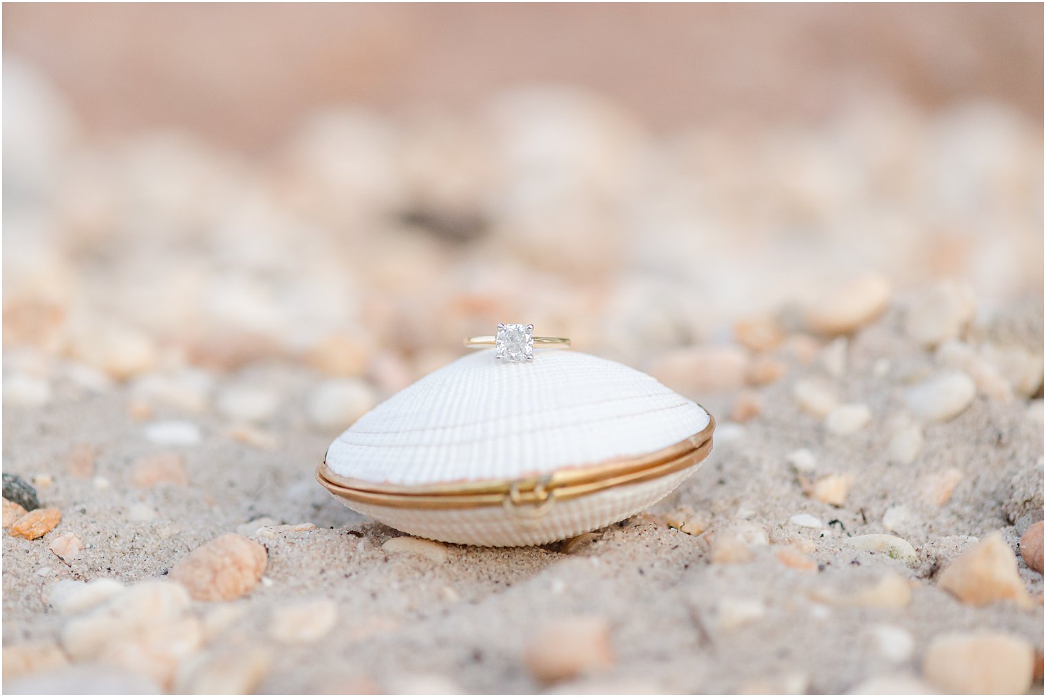 diamond ring rests on white clam shell ring box
