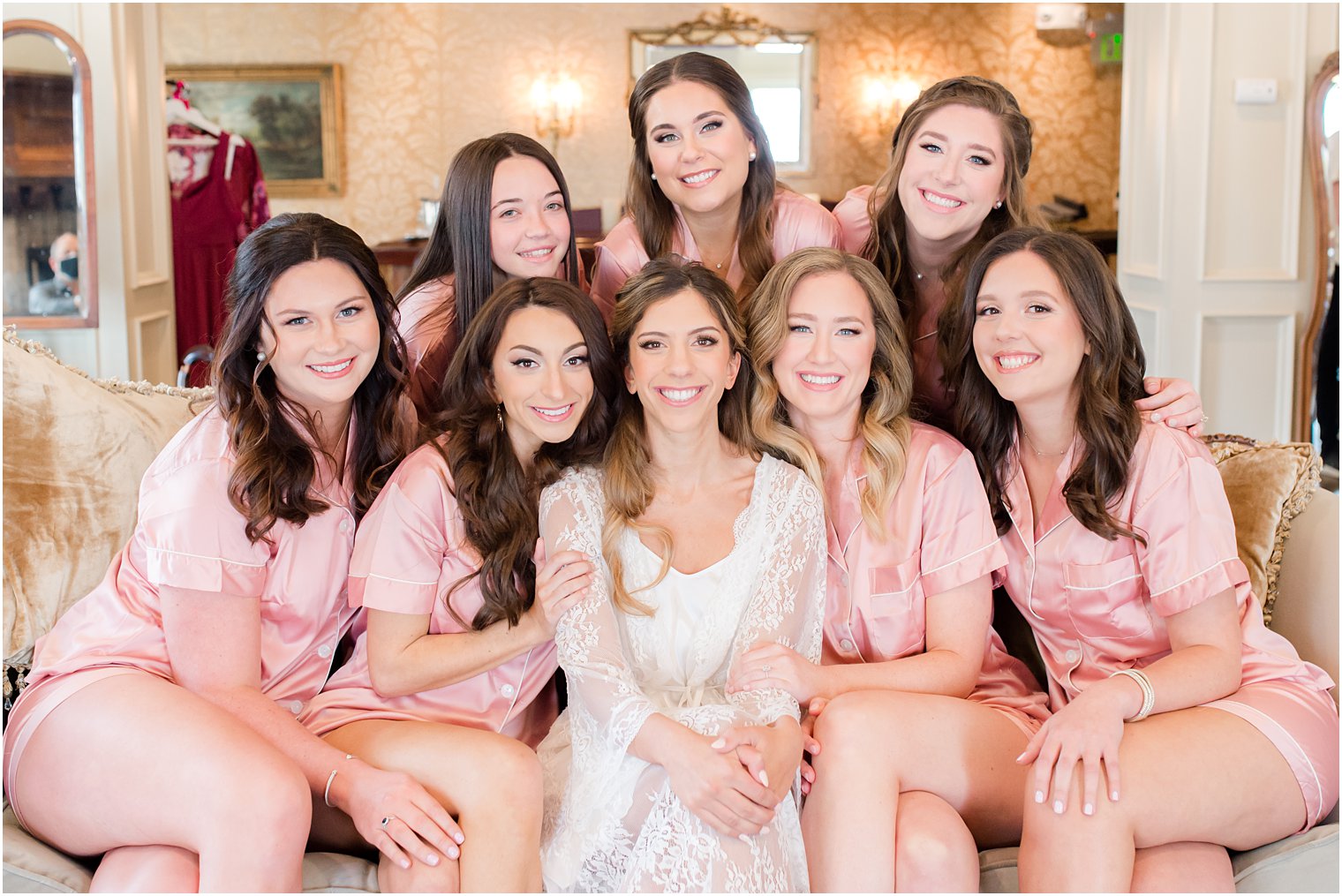 bride sits with bridesmaids in pink robes before wedding at Park Savoy Estate