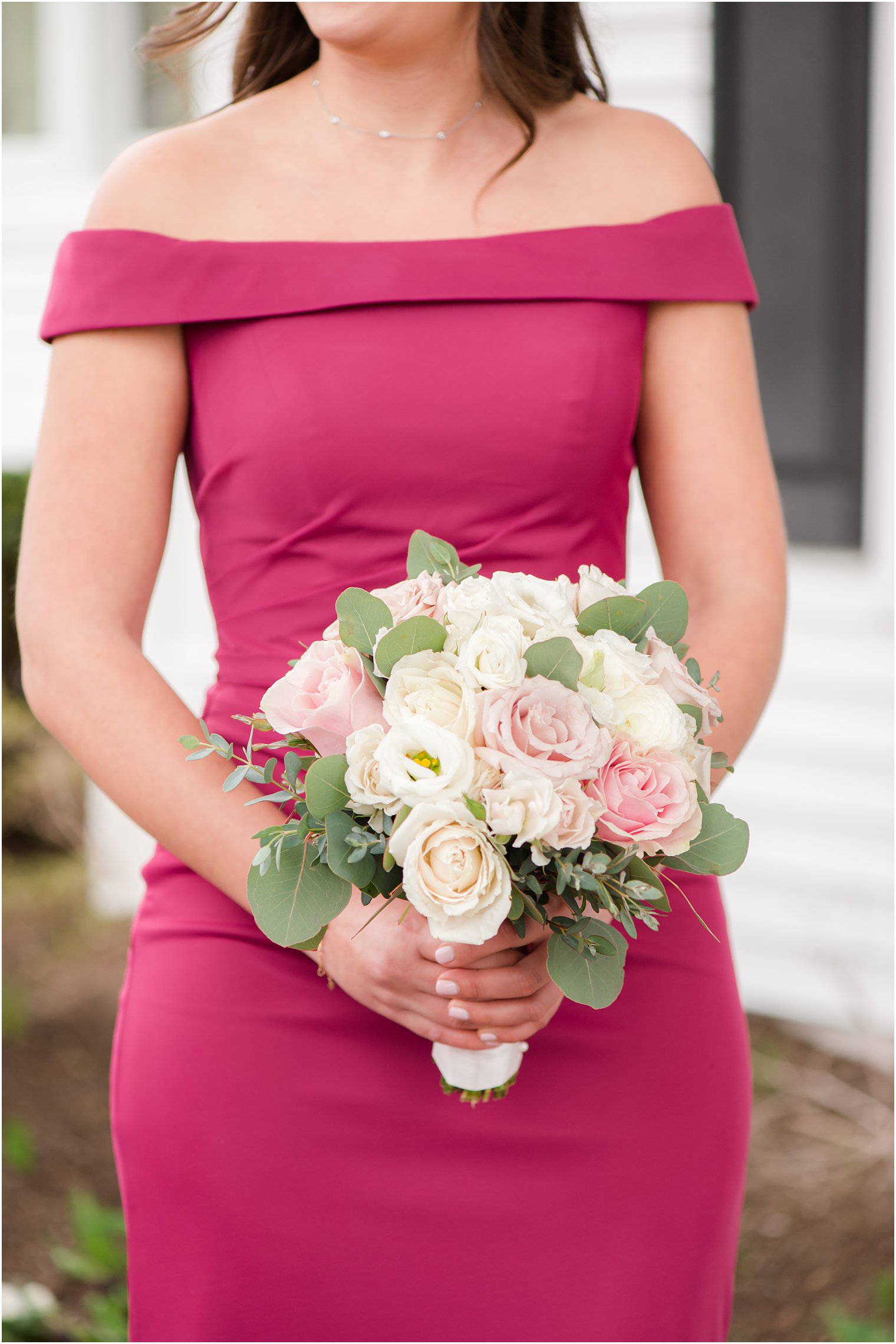 bridesmaid in magenta gown holds bouquet of pink and white flowers 