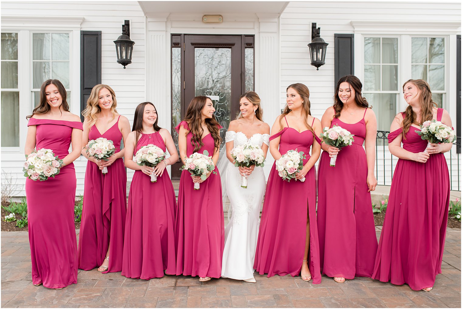 bridesmaids in magenta gowns walks with bride outside Park Savoy Estate