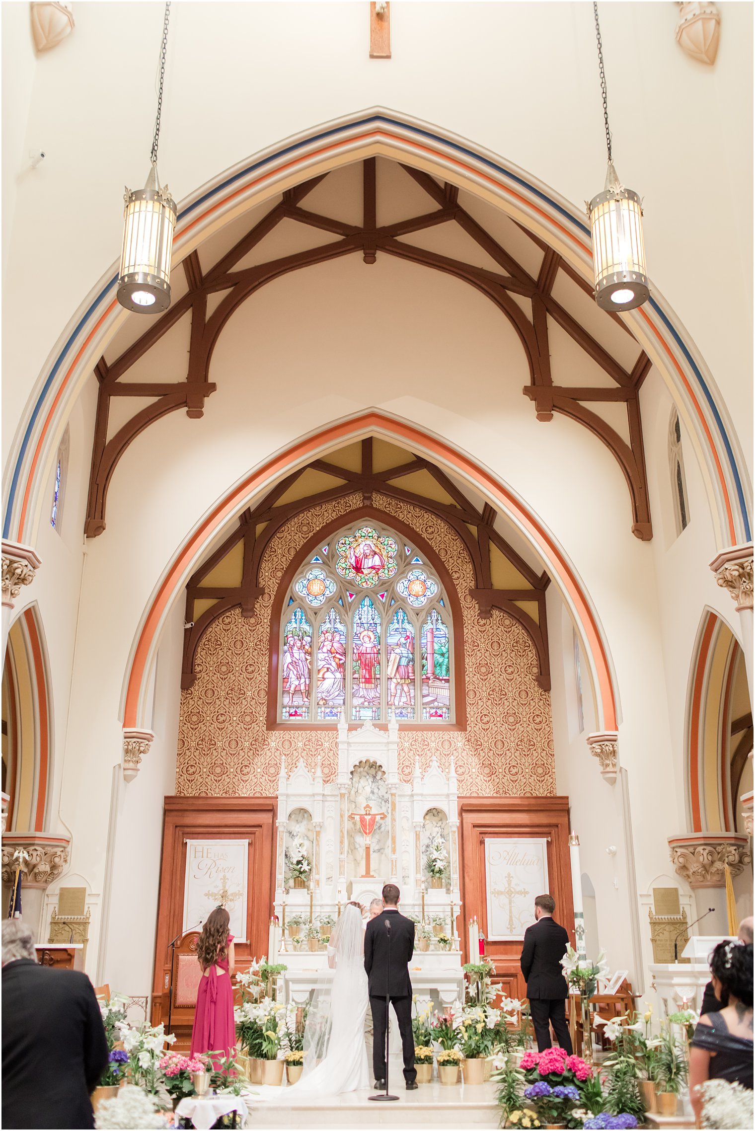 bride and groom stand at alter during ceremony at St. Vincent's Martyr Catholic Church