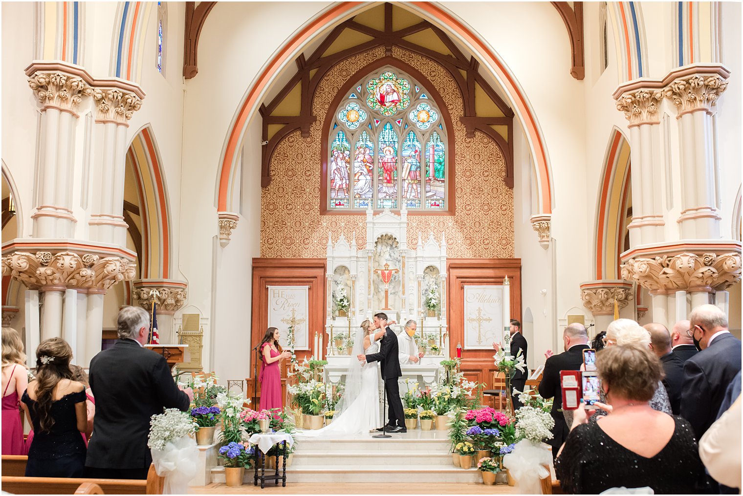 newlyweds kiss during ceremony at St. Vincent's Martyr Catholic Church