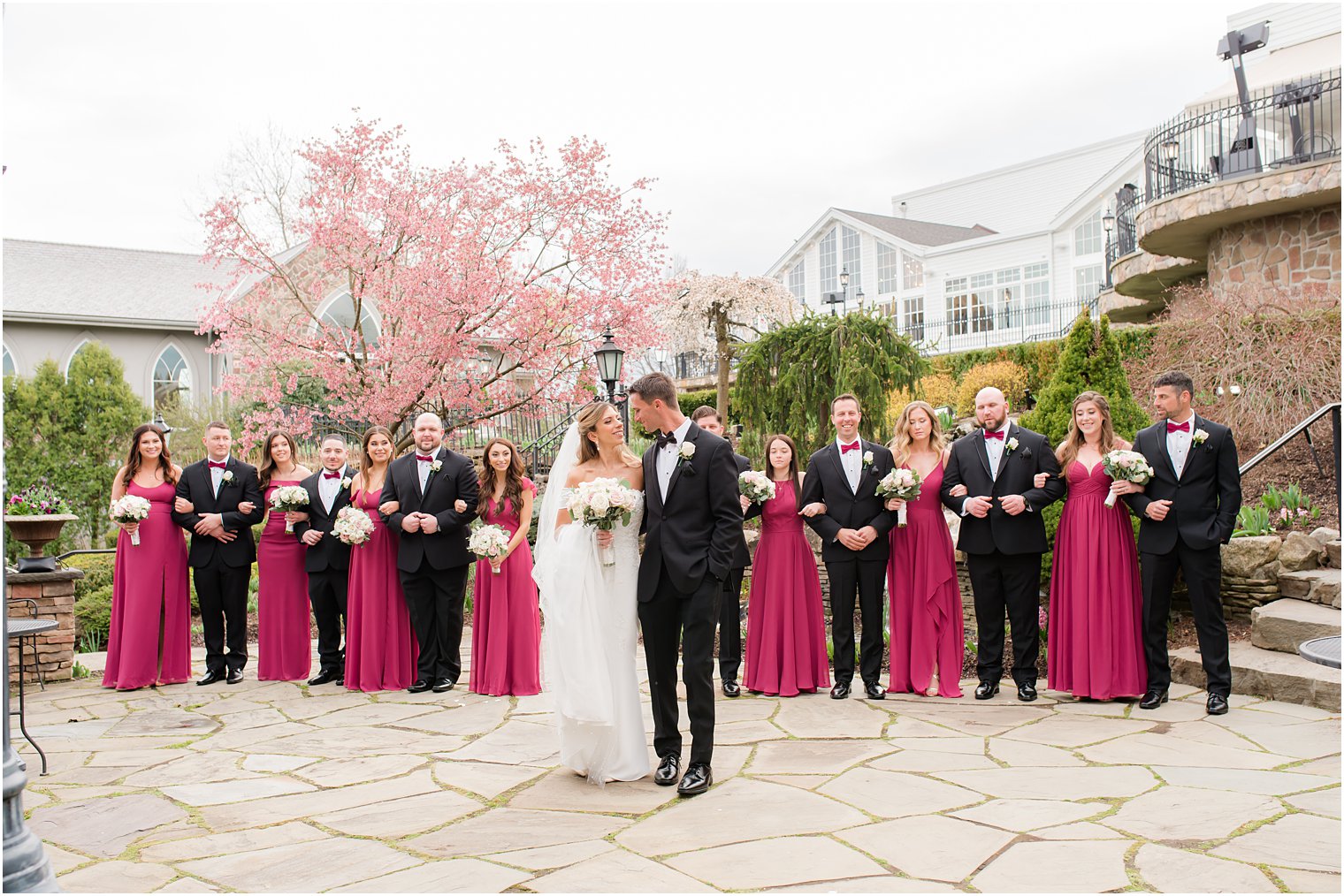 newlyweds walk in front of wedding party in pink and black at Park Savoy Estate