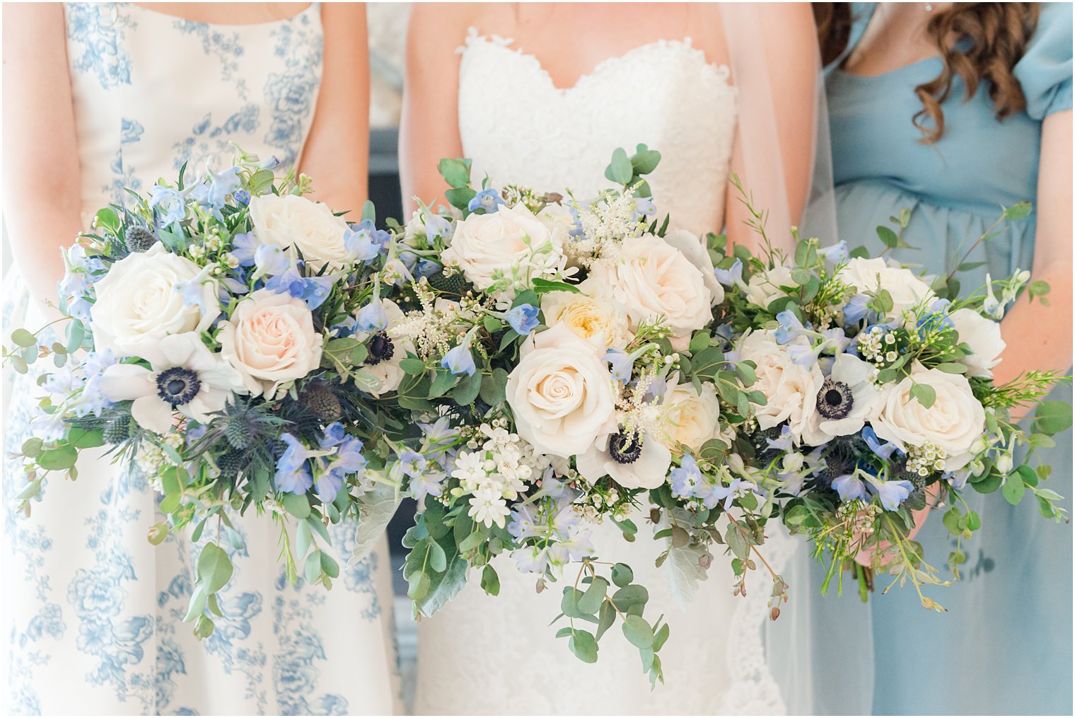 bride and bridesmaids hold blue and ivory bouquets