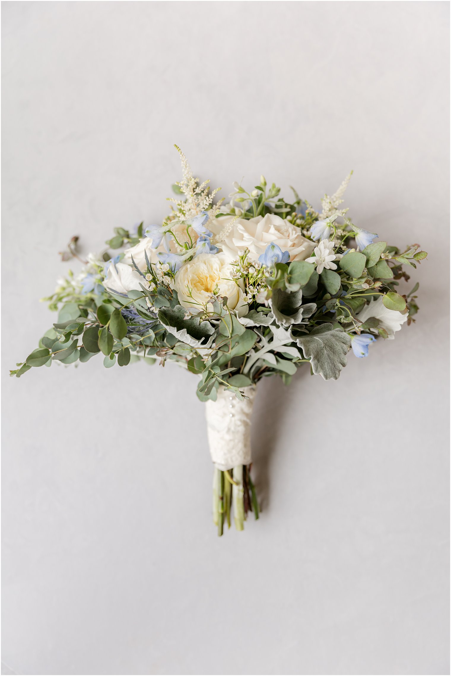 wedding bouquet with ivory roses and blue flowers 