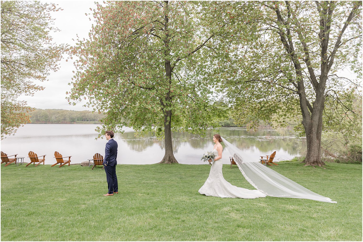 bride walks to groom for first look by lake at Indian Trail Club