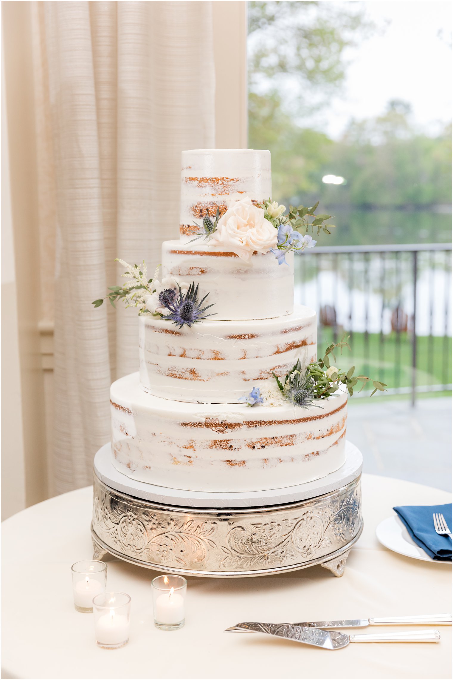 tiered naked wedding cake with greenery accents 