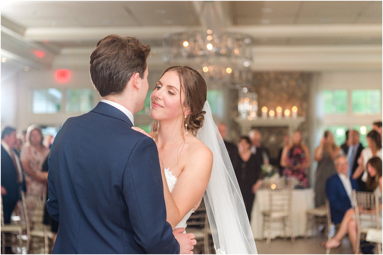 bride smiles at groom during reception in ballroom