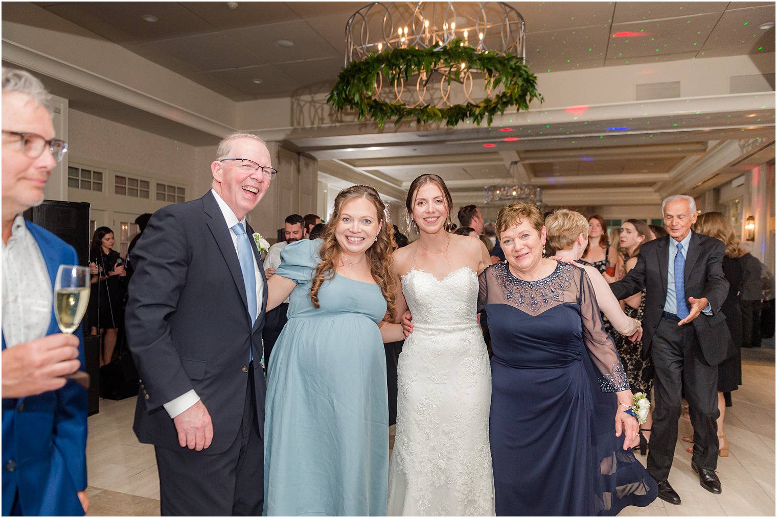 bride poses with family during NJ wedding reception 