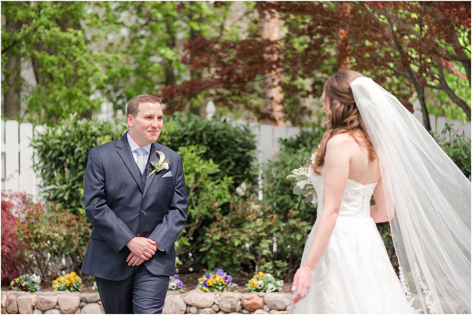 groom turns to see bride during first look in gardens of The English Manor