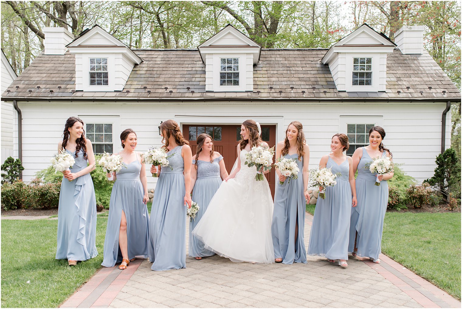 bride walks with bridesmaids in light blue gowns at The English Manor