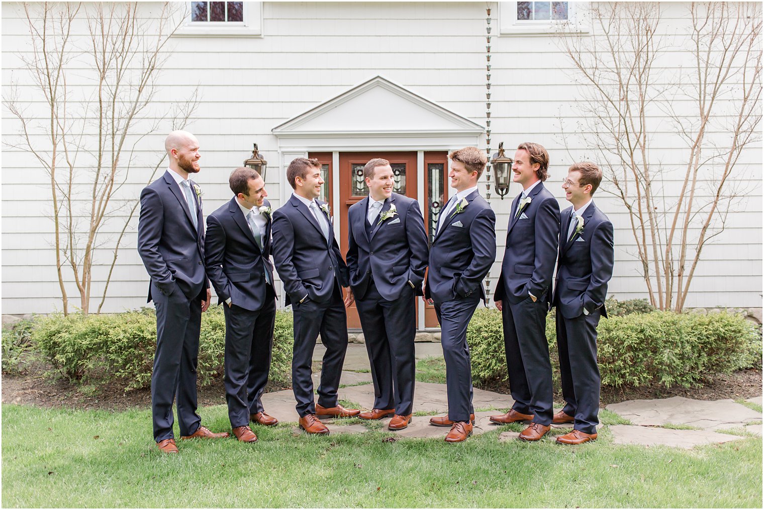 groom looks at groomsmen in navy suits at The English Manor