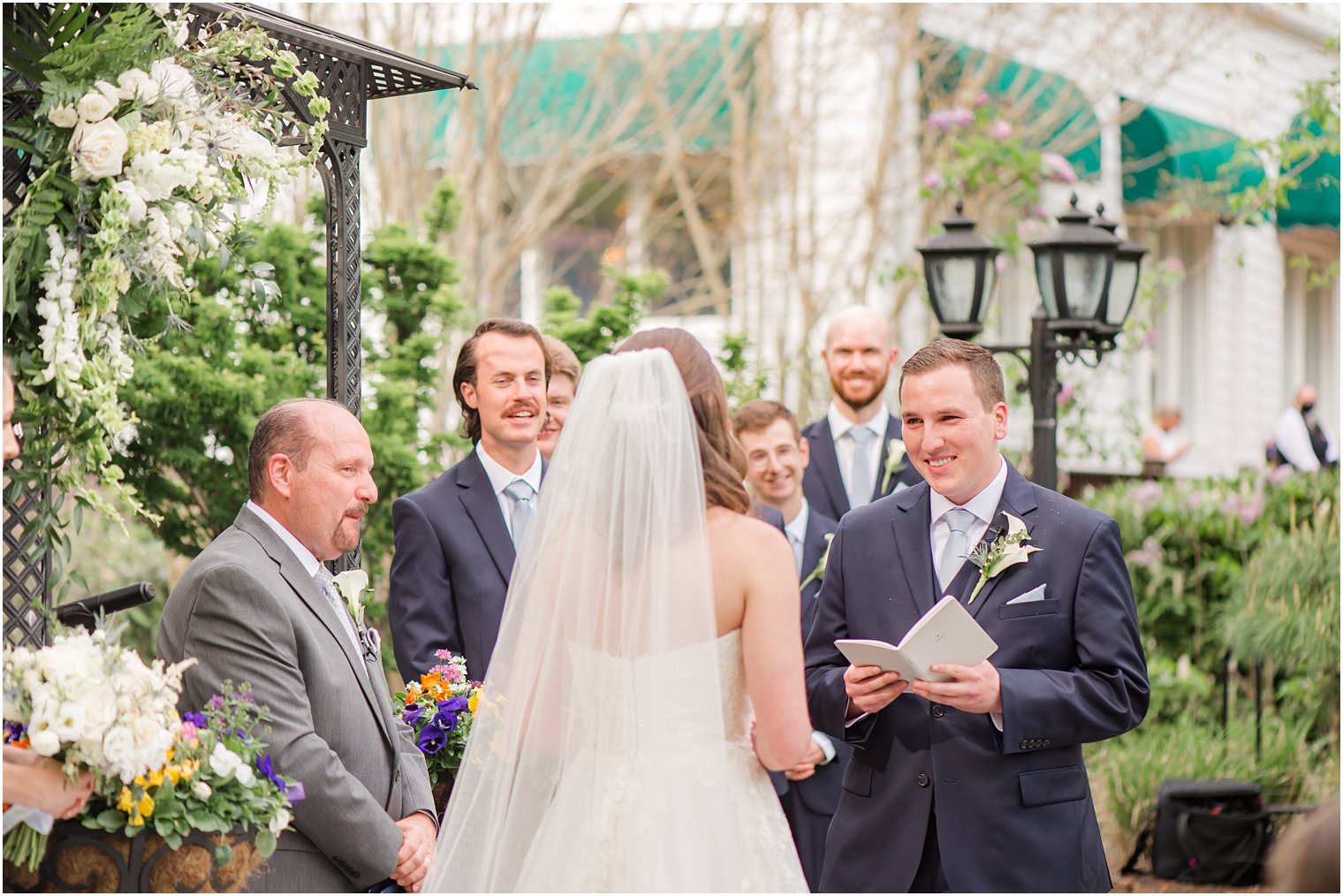 groom reads bride vows during garden wedding ceremony 