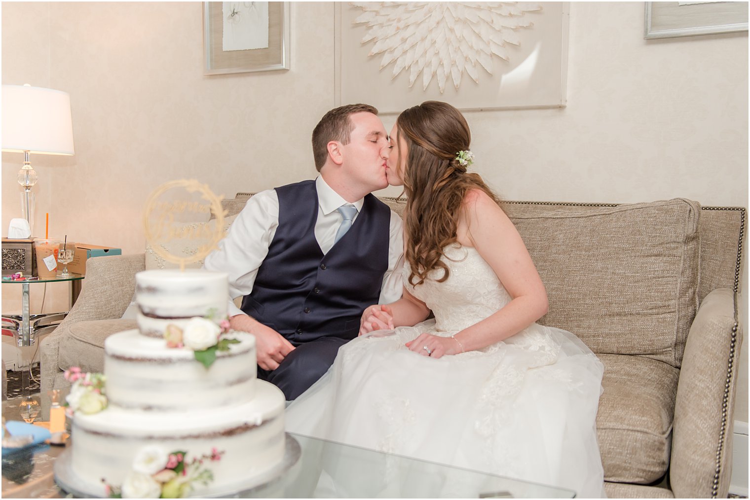 newlyweds kiss sitting on couch at The English Manor 