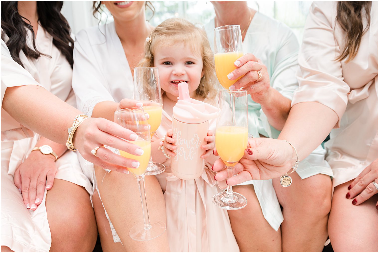 bridesmaids and bride toast mimosas with flower girl's sippy cup 