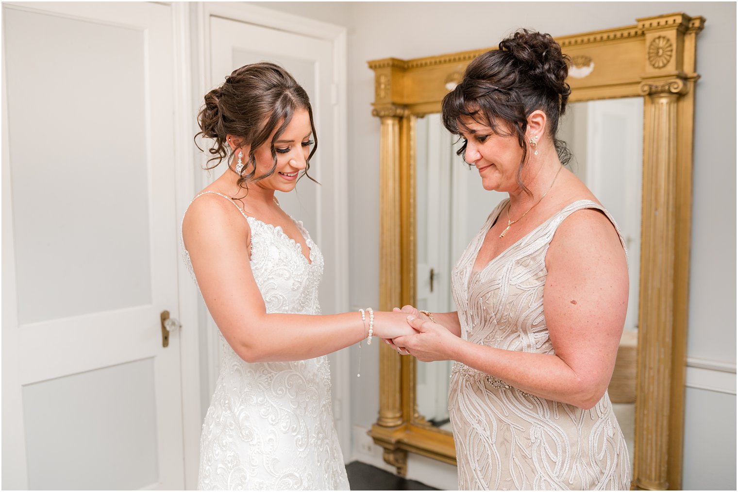 mother helps bride with jewelry on morning of wedding at The Inn at Fernbrook Farms