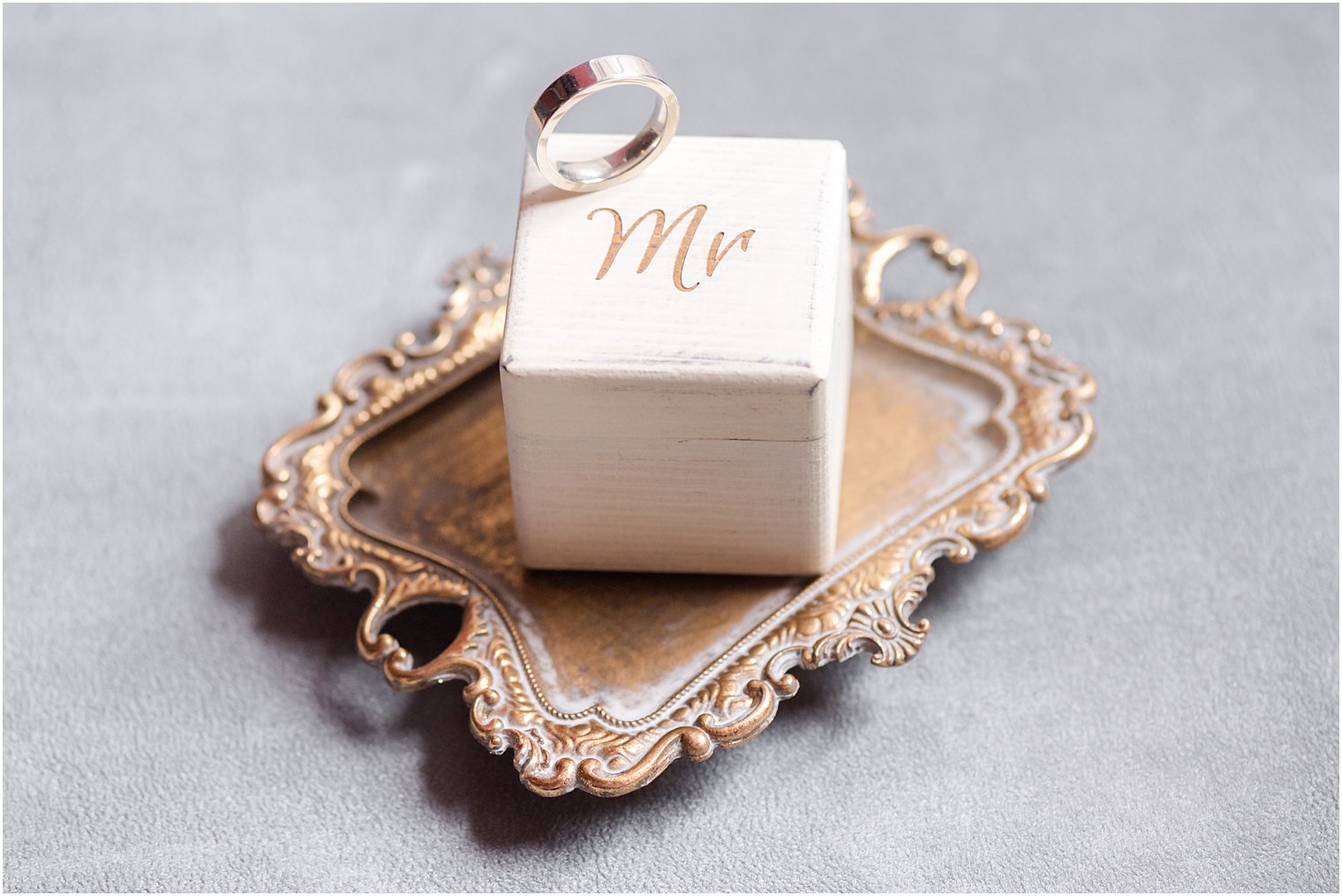 groom's ring rests on top of white MR box