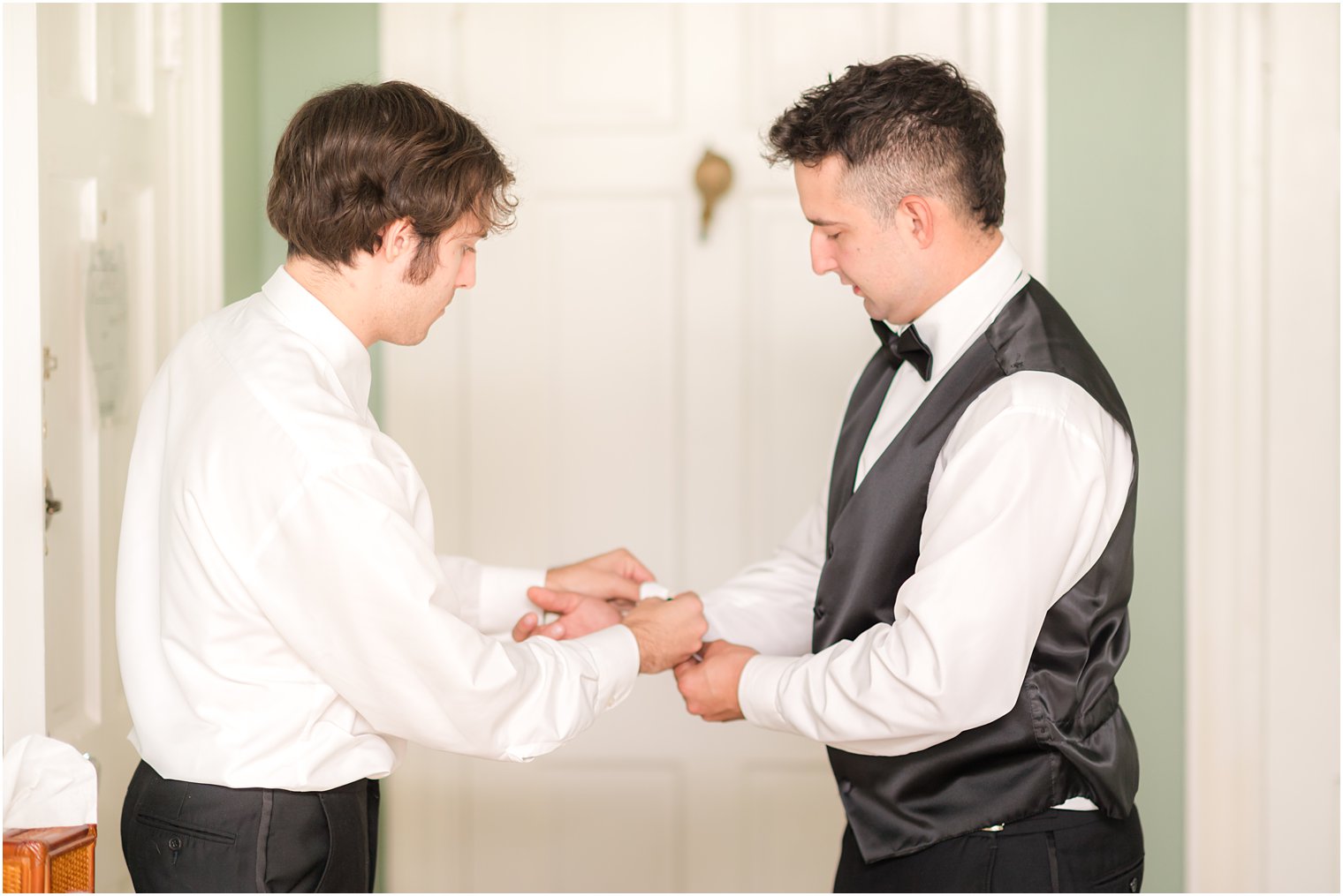 groom helps groomsman with cufflinks before NJ wedding