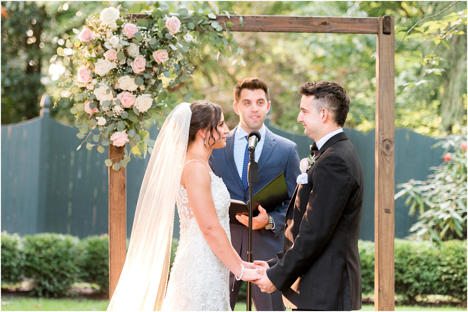 couple exchanges vows during wedding ceremony in garden at The Inn at Fernbrook Farms