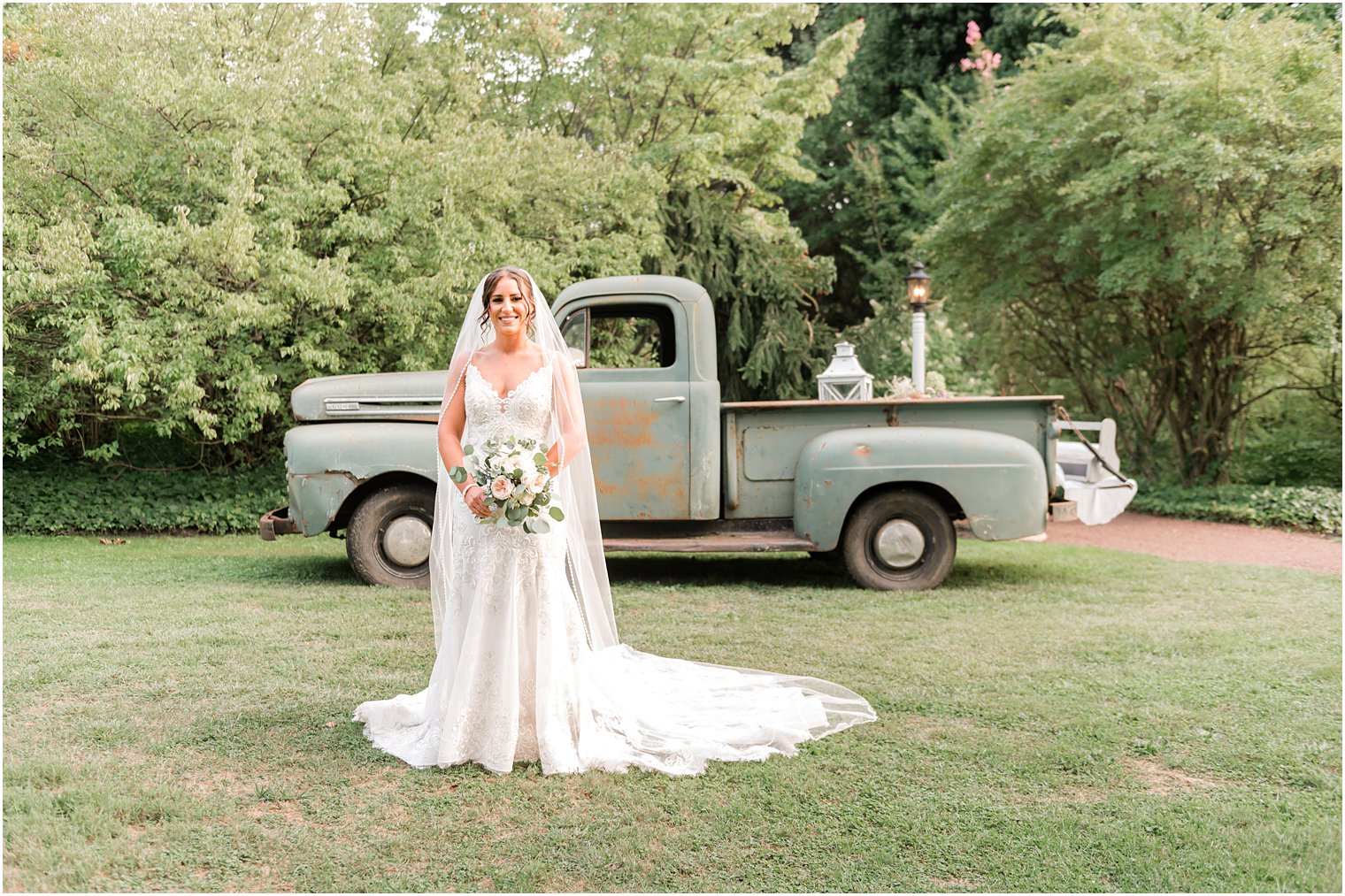 bride stands by vintage green truck at The Inn at Fernbrook Farms