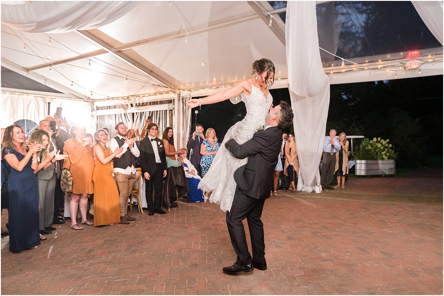 groom lifts up bride during first dance 