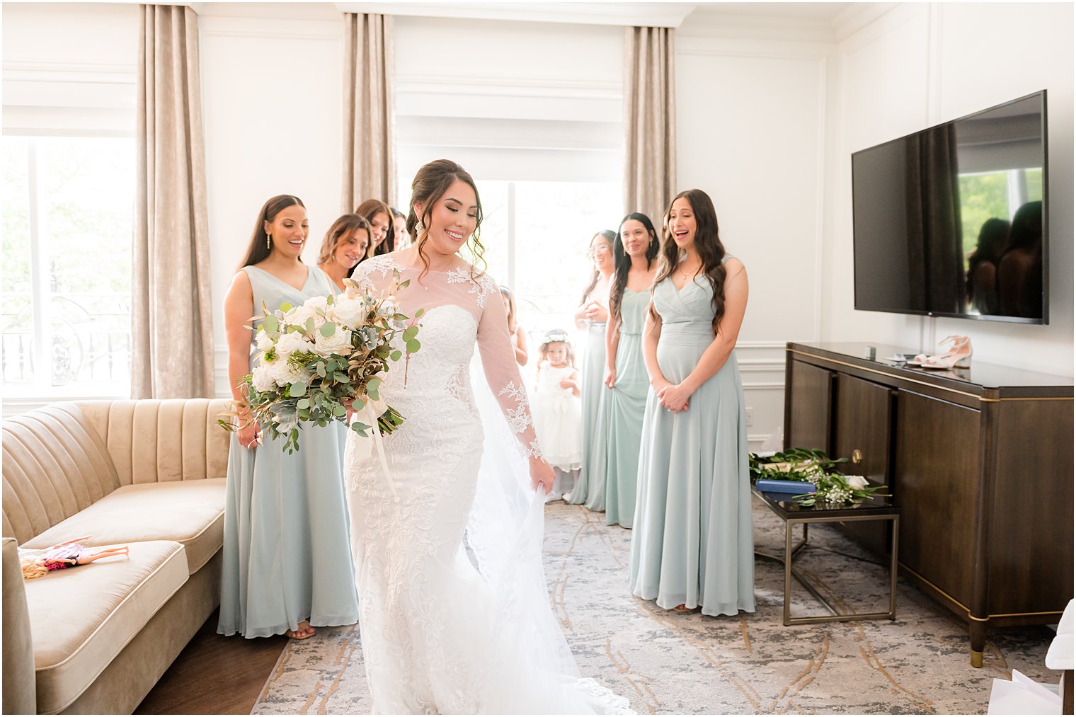 bridesmaids in mint green gowns look at bride during first look 