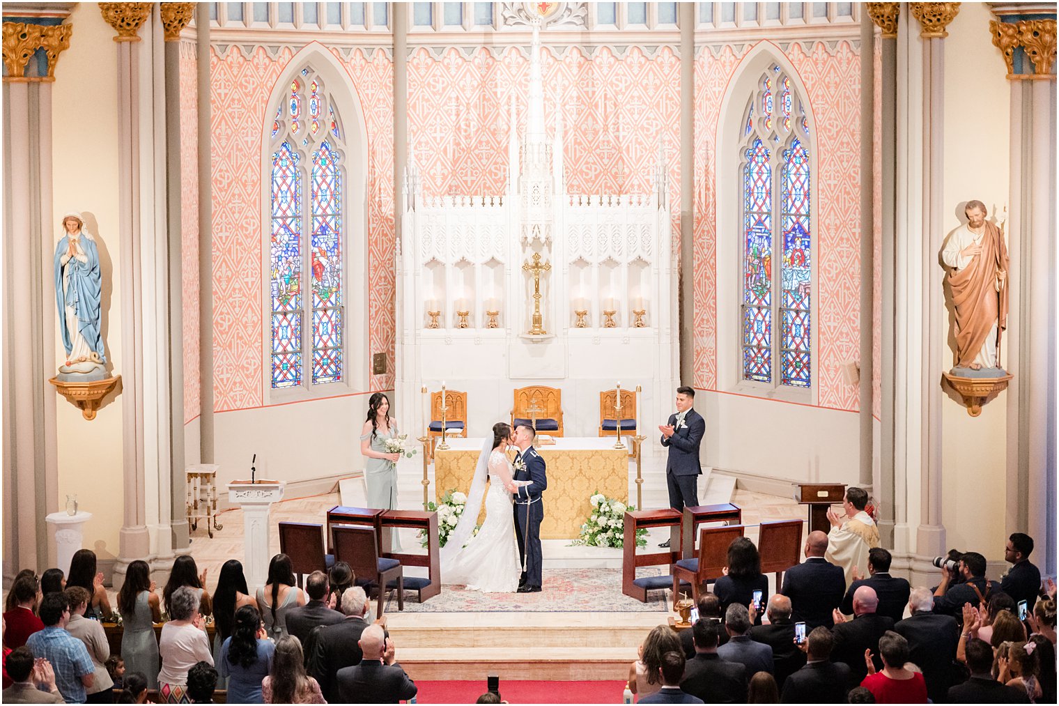 newlyweds kiss by alter during wedding ceremony at St. Peter's Catholic Church