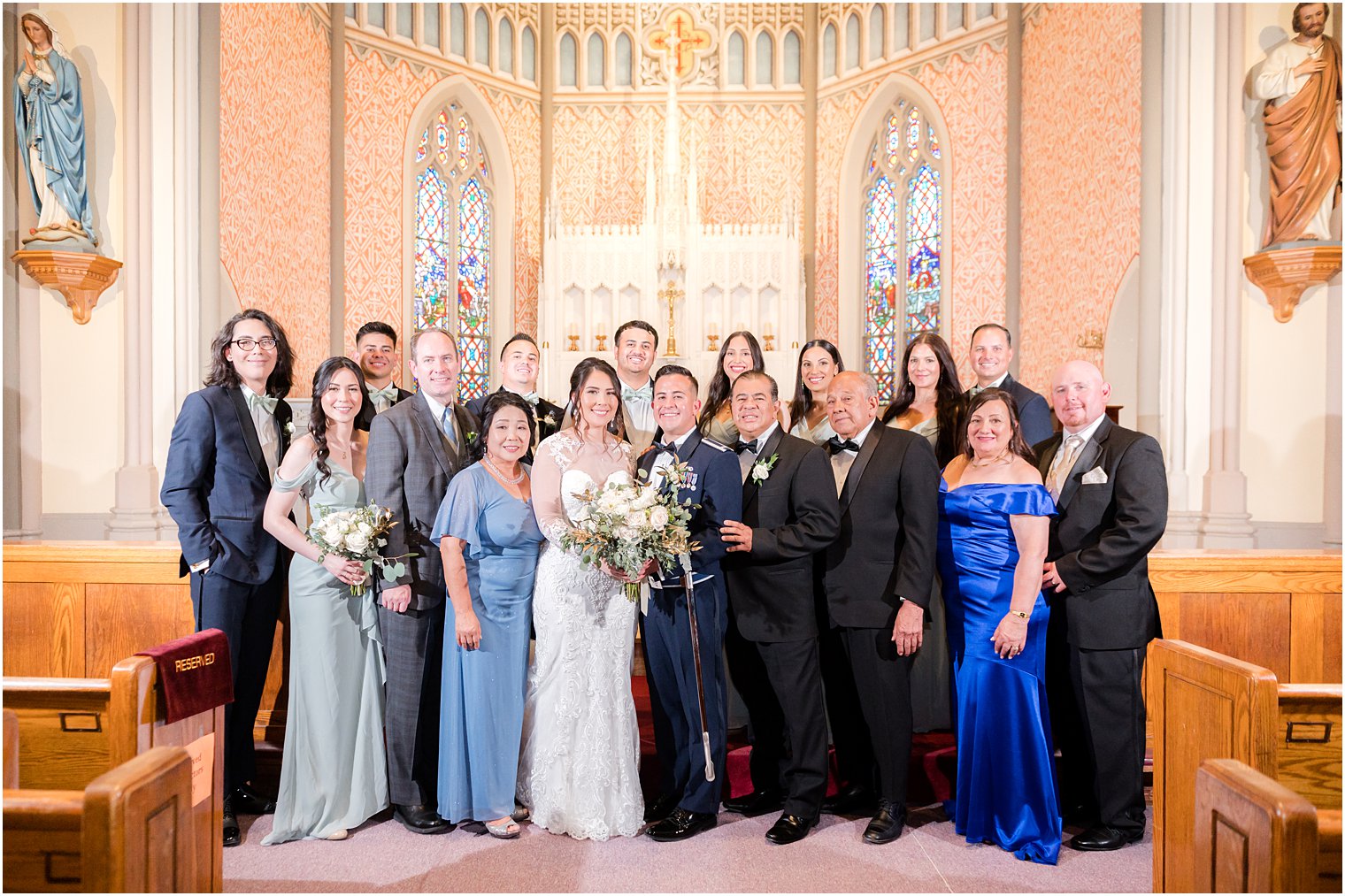 bride and groom pose with parents and family at St. Peter's Catholic Church