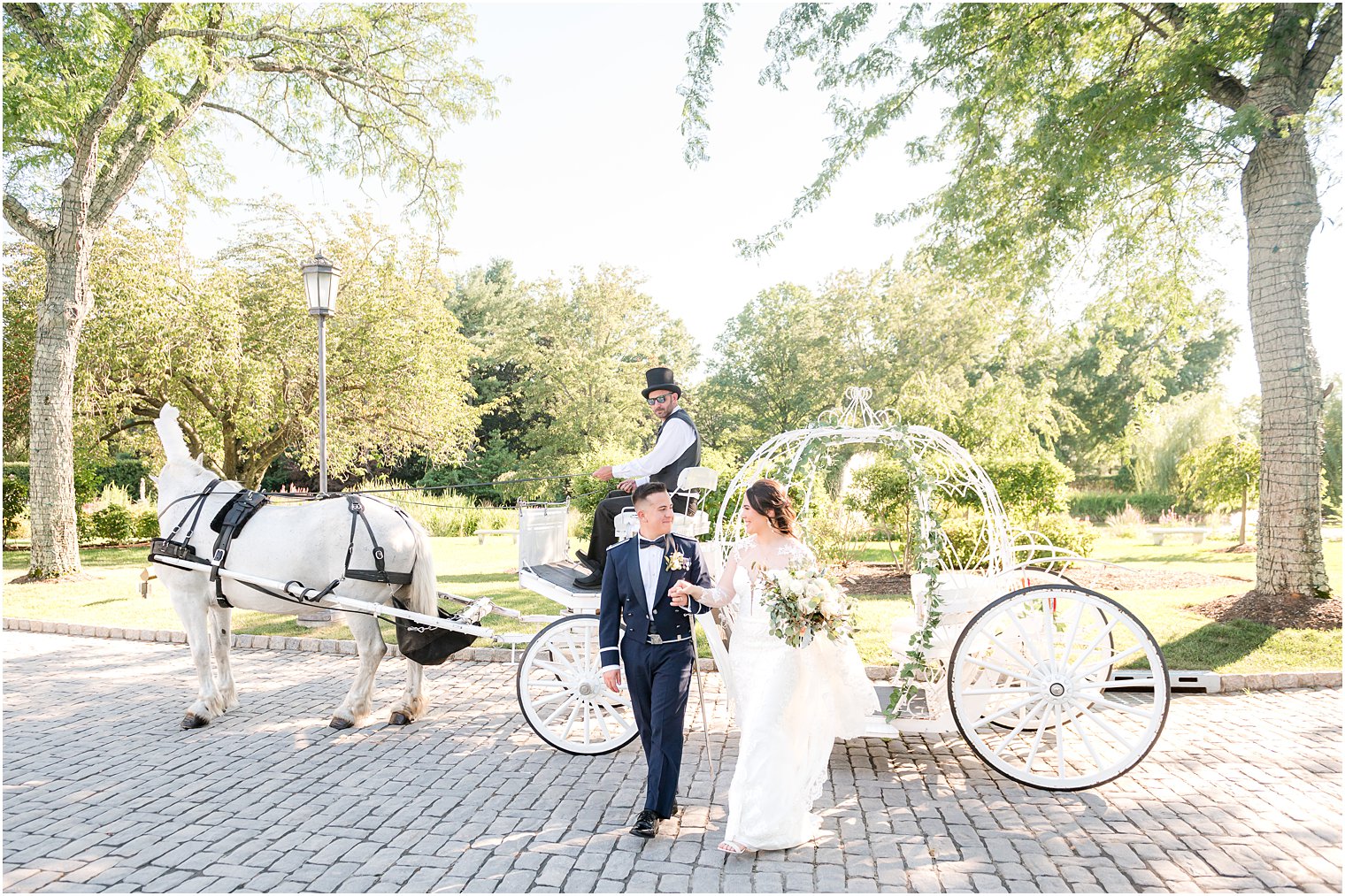 newlyweds hold hands walking away from carriage in front of Park Chateau Estate